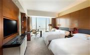 希尔顿高级客房 - 45平方米双床房，宽敞舒适，搭配明亮的落地窗，秀美的山景和动感的城市天际线尽收眼