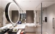 卫浴空间整体色调明亮，设计灵感来源于北京园林里常见的月亮门，以镜中镜的方式完善化妆镜的立面设计，增强